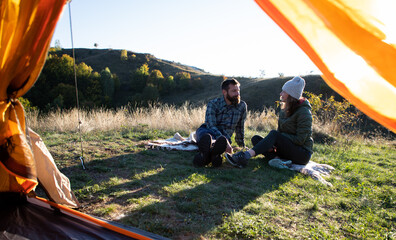 Poster - happy friends camping with dog in autumn landscape