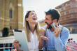 © Mediteraneo - Young couple using a digital tablet for online shopping outdoor.