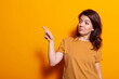 © DC Studio - Caucasian person indicating finger at left side of studio while posing for pictures and photography. Cheerful woman looking aside while doing gesture and sign with hand over background.