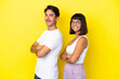 © luismolinero - Young mixed race couple isolated on yellow background keeping the arms crossed in lateral position while smiling