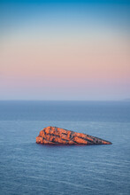 Rocky Isolated Islet In Sea At Sunrise. Benidorm Island, Alicante, Spain