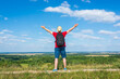 © ARVD73 - Tourist man with backpack enjoying the view in nature.Traveler man with backpack,arms outstretched stand on blue sky.