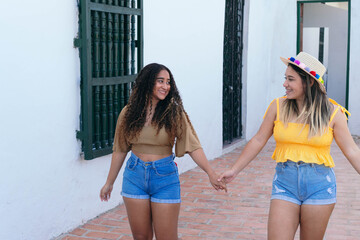 Two Latin Girls Walking Down The Street