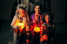 Kids In Halloween Costumes And Glowing Jack O Lanterns In Night