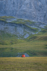 Fototapete - A single red tent at lake d'Anterne, France.
