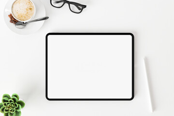 Top view of blank screen tablet on white working desk