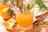 Autumn alcohol drinks. Spicy boozy gin persimmon cocktail with rosemary and cinnamon