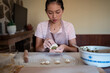 © ADDICTIVE STOCK - Female cook stuffing dough with meat