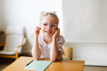 Wall Mural - Children in class do exercises, kids pupils rub their ears and show faces, break in the lesson, dynamic pause, Concept learning, private small school, extracurricular activities