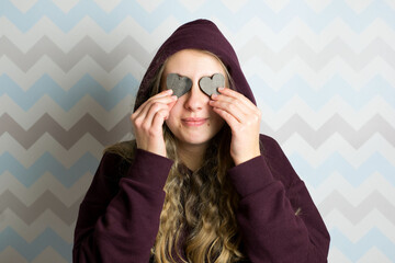 woman girl holding heart eyes with her hands wearing a hoodie smiling happy love long hair