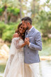 © ADDICTIVE STOCK - Newlywed couple holding hands near pond and trees in park