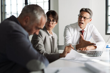 Angry businessman discussing with his colleague on a business meeting in the office