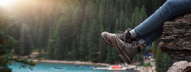 legs of woman hiker sitting on rocks resting after a hike enjoying a view web banner