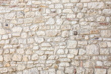Stone Antique Old Wall As A Background Or Texture. Vintage Background Of A Fortress Wall In Loft And Grunge Style With Place For Text And Copy Space.