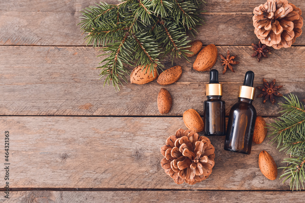 Bottles of essential oils on wooden background