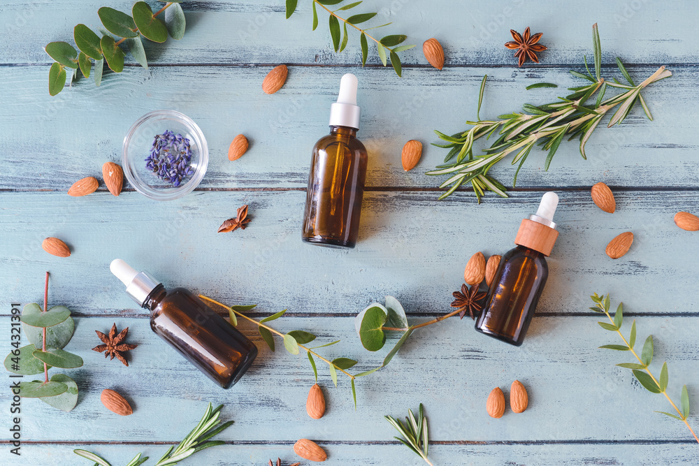 Bottles of essential oils on wooden background