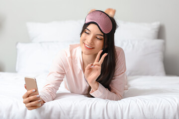 Sticker - Pretty young woman taking selfie and showing victory gesture in bedroom