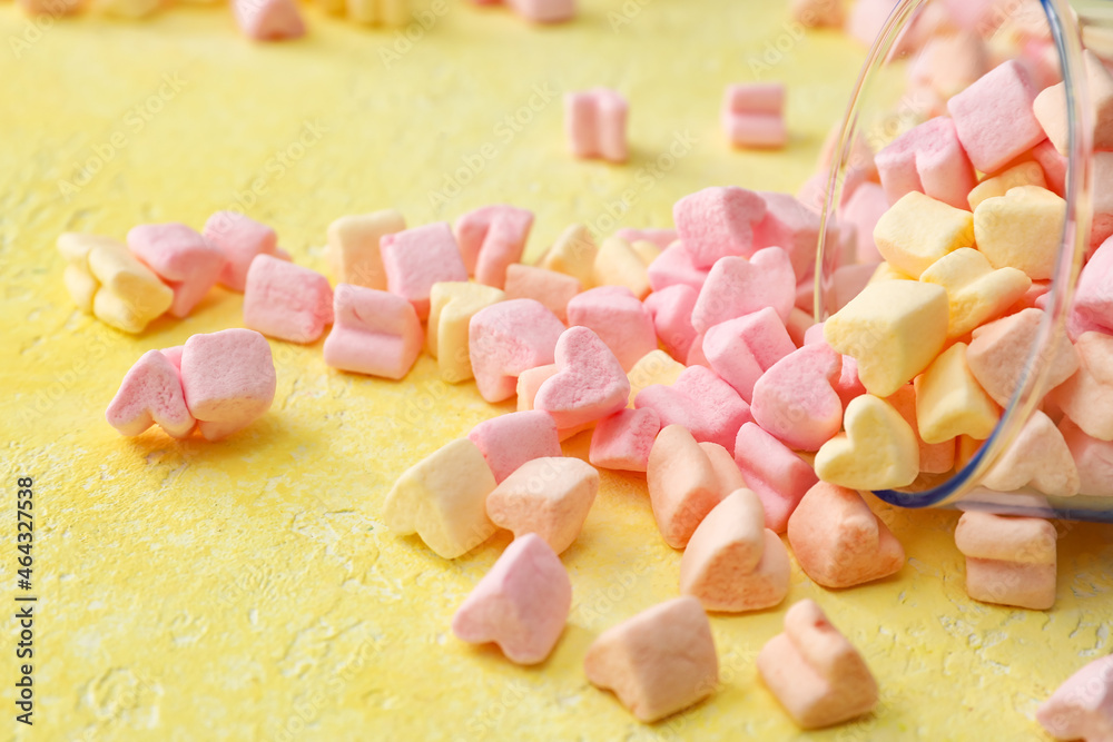 Glass with tasty marshmallows on color background, closeup
