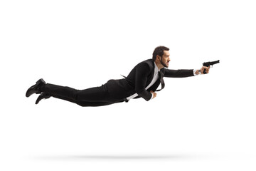 Sticker - Full length profile shot of a man in a suit flying and holding a gun