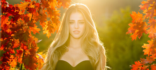 beautiful woman enjoying autumn. banner of blonde hair model with maple fall leaf.