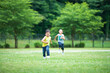 © amanaimages - 緑の芝生を元気よく走る男の子の兄弟