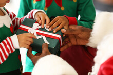 Santa Claus Giving Present To Little African-American Children At Home
