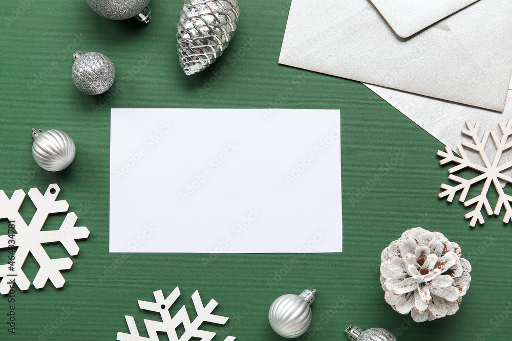 Beautiful Christmas composition with blank card and envelope on green background, closeup