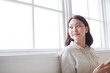 © amanaimages - 窓に寄りかかる若い女性