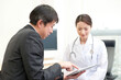 © amanaimages - 診察室でタブレットPCで情報提供するＭＲと女医