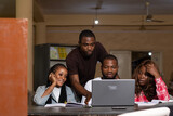 Fototapeta Tulipany - a group of black students studying together, using a laptop to discuss their work