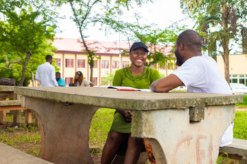 Happy young university students studying with books in the campus