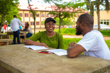 black university handsome man assisting his female friend with her lecture in the campus. focus is o