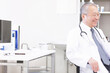 © amanaimages - 診察室で座って談笑する医師