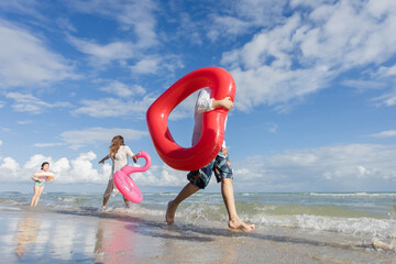 Happy young family Asian running on the beach with copy space. family enjoying