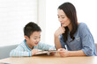 © amanaimages - タブレットPCを見る男の子と母親