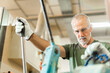 © Iván Moreno - Older worker threading a steel bar in an industrial factory