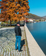 © bogdan vacarciuc - A man walks alone through the public park and looks at the lake on an autumn day. Outdoor time.