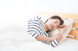 © amanaimages - ベッドで眠る日本人女性