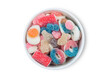 Fruit flavour gums candies with a sour sugar coating in ceramic bowl on white background.