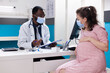 © DC Studio - Woman expecting child and having discussion with physician about pregnancy and healthcare. General practitioner giving medical advice to pregnant patient during coronavirus pandemic