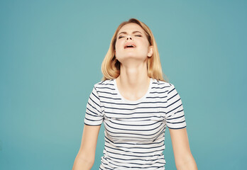 Wall Mural - blonde girl in striped t-shirt fun glamor posing blue background