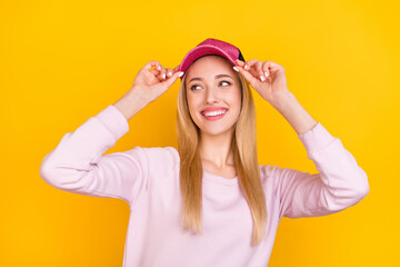 Canvas Print - Photo of young cheerful girl happy positive smile hands touch hat look empty space isolated over yellow color background