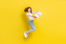 Full Length Photo Of Happy Brown Haired Little Girl Jump Up Hold Hands Gift Box Isolated On Yellow Color Background