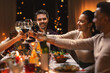 © Syda Productions - holidays, party and celebration concept - multiethnic group of happy friends having christmas dinner at home and drinking wine