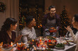 © Syda Productions - holidays and celebration concept - multiethnic group of happy friends having christmas dinner at home