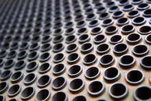 Tube Sheet Or Plate Of Heat Exchanger Or Boiler Selective Focus Shot At An Angle Closeup Texture Industrial Background, With Insoluble Hard Mineral Deposits Salts Scale And Corrosion With Copyspace.