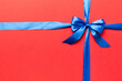 © sosiukin - Top view of blue ribbon rolled and blue bow isolated on colored background. Flat lay with copy space