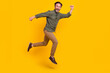 Full length body size view of attractive cheery lucky man jumping going isolated over vivid yellow color background