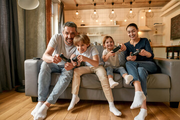 Wall Mural - Overjoyed family with kids play video games at home