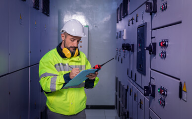 Wall Mural - Engineer checking and inspecting at MDB panel , working with electric switchboard to check medium Voltage Switchgear working in Main Distribution Boards factory.